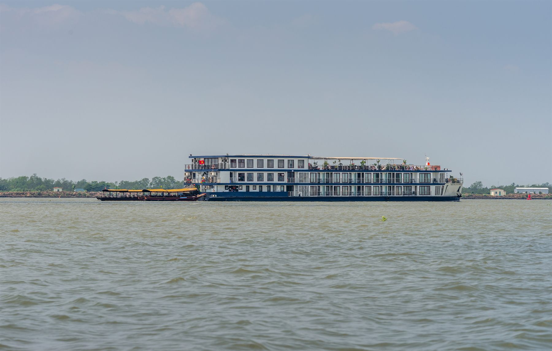 Four-deck river cruise ship on a broad, calm river
