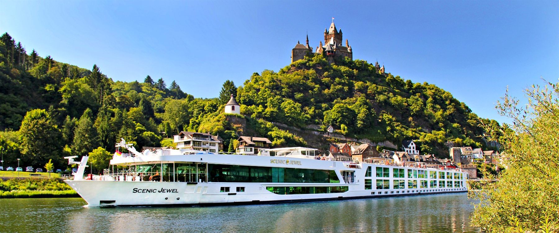 Scenic Jewel river ship moored below a hilltop castle